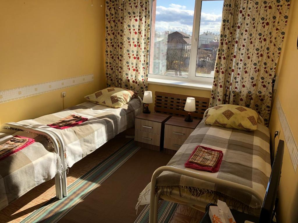ユジノ・サハリンスクにあるКомфорт гостевой домのツインベッド2台 窓付きの部屋