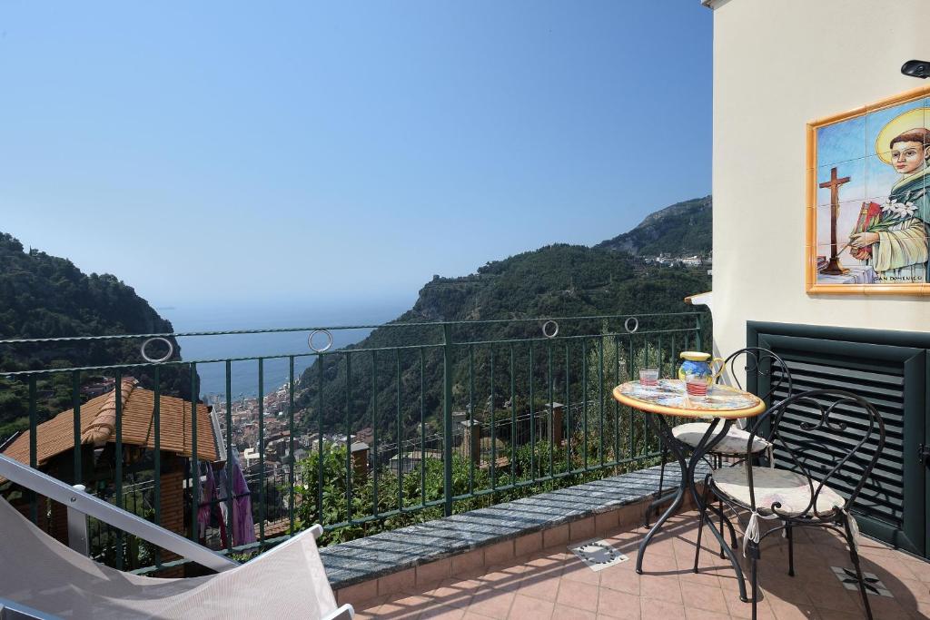 balcón con mesa, sillas y vistas en Pontone on the sea apartment, en Scala