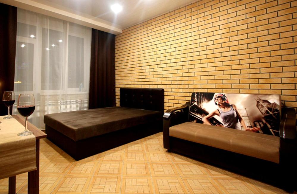 エカテリンブルクにあるулица Крестинского 35のレンガの壁、ベッド2台が備わる客室です。