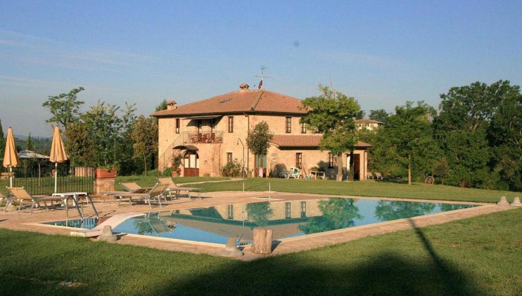 una casa grande con piscina frente a ella en La Casa Del Fattore, en Monteriggioni