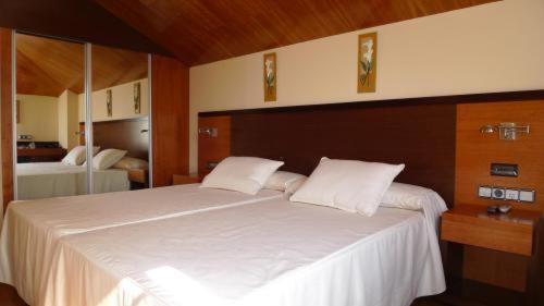 a bedroom with a large white bed with a mirror at Doade in Hio