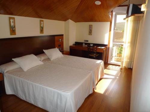 a bedroom with a large white bed and a desk at Doade in Hio