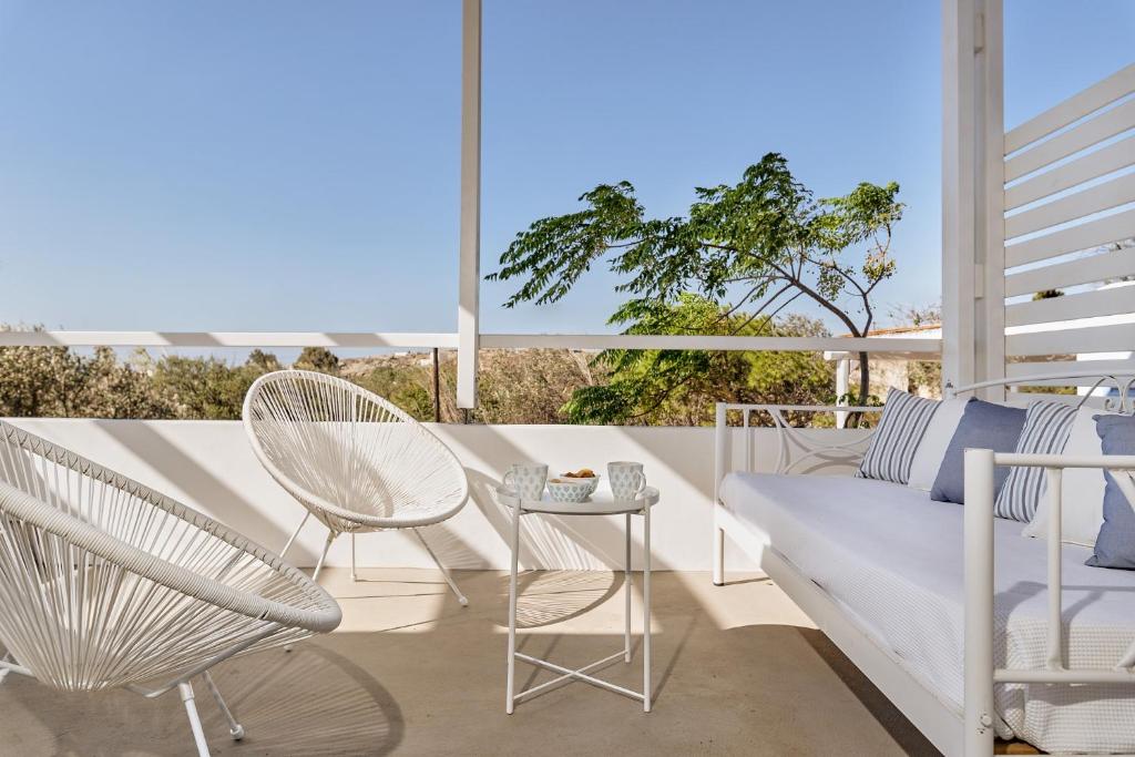 een patio met een bank, stoelen en een tafel bij My Chorio Mykonos Country Summer House in Platis Yialos Mykonos