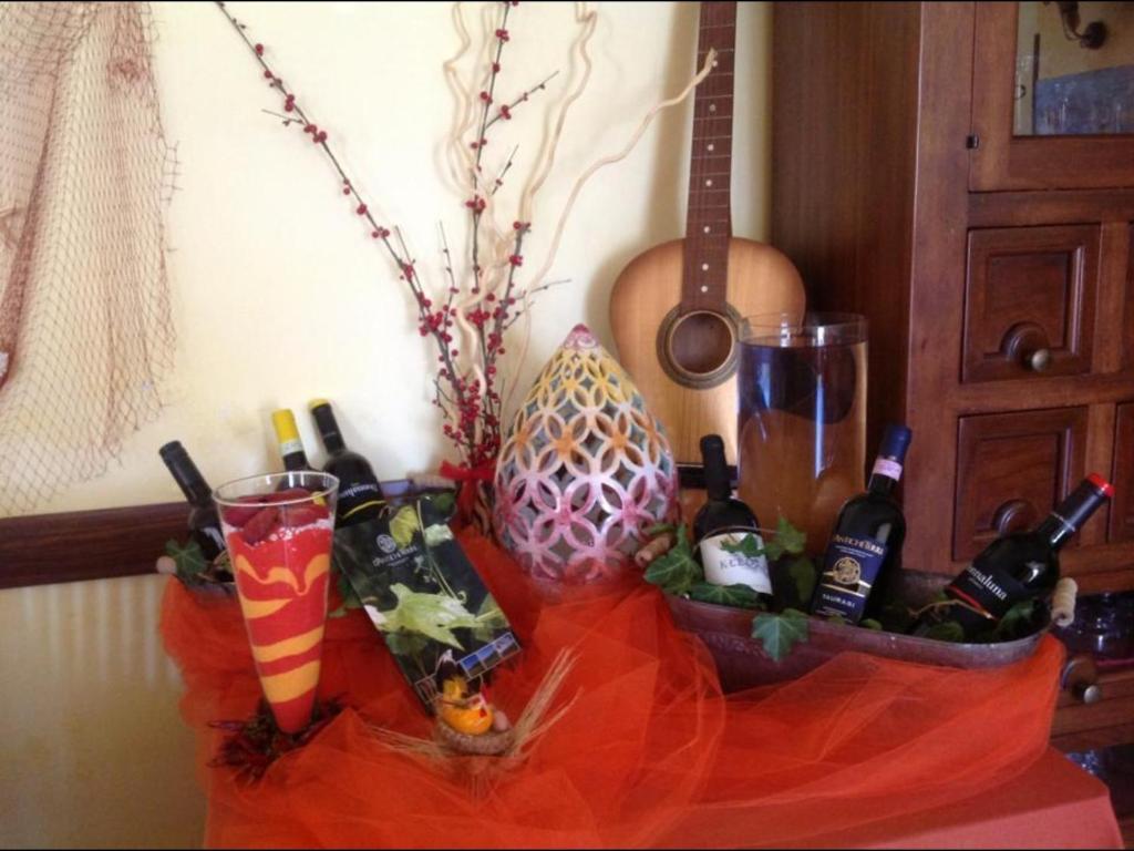 uma mesa coberta com garrafas de vinho e um vaso em Monte Degli Ulivi Country House em Mercato San Severino