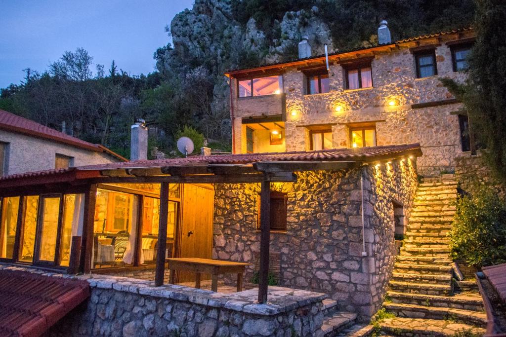 ein großes Steinhaus mit einer Treppe davor in der Unterkunft Stone house on the rock in Lílaia