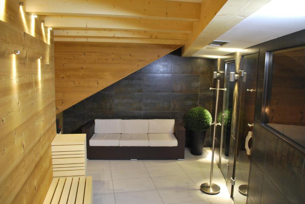 - un salon avec un canapé blanc et un escalier dans l'établissement Piccolo Hotel, à Canazei