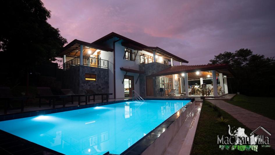 a house with a swimming pool at night at Machan Villa in Tangalle