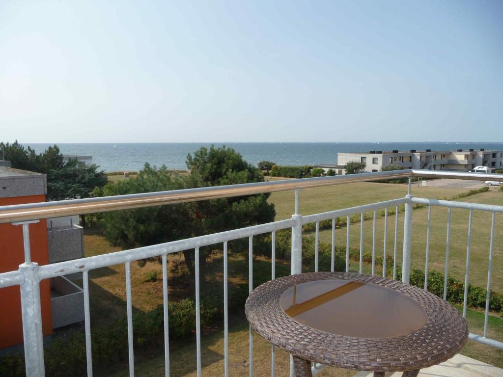 a balcony with a table and a view of the ocean at STHS78213-FeWo-Fehmarnstrand-II in Staberdorf