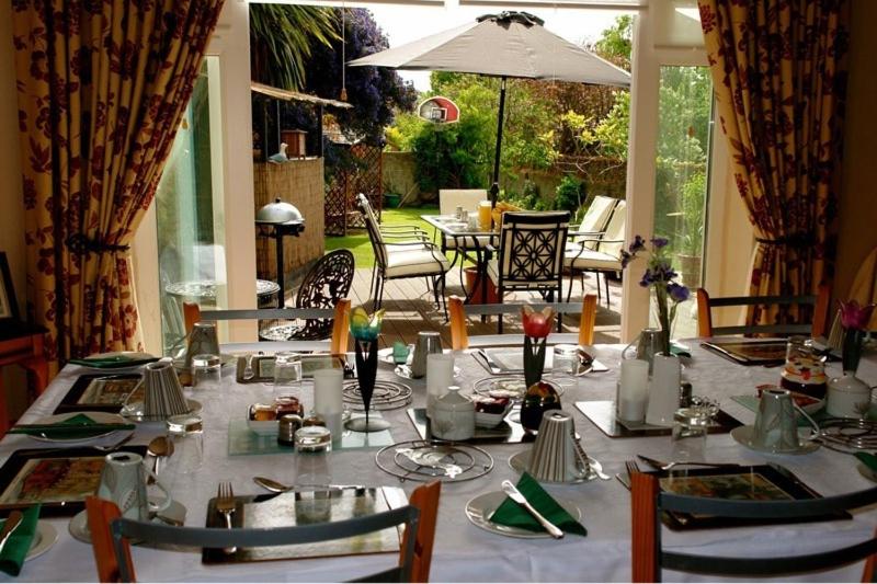 tavolo da pranzo con tovaglia e sedie bianche di Annandale House a Dublino