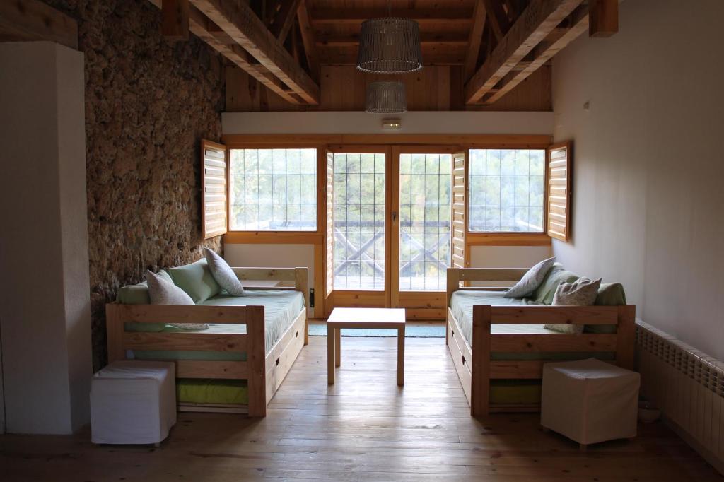 a room with two beds and two windows at Albergue Tejadillos in Cuenca