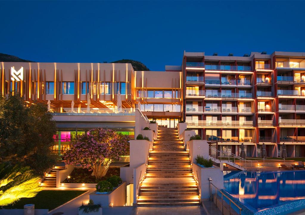 a view of a building with a swimming pool at night at Maestral Resort & Casino in Sveti Stefan