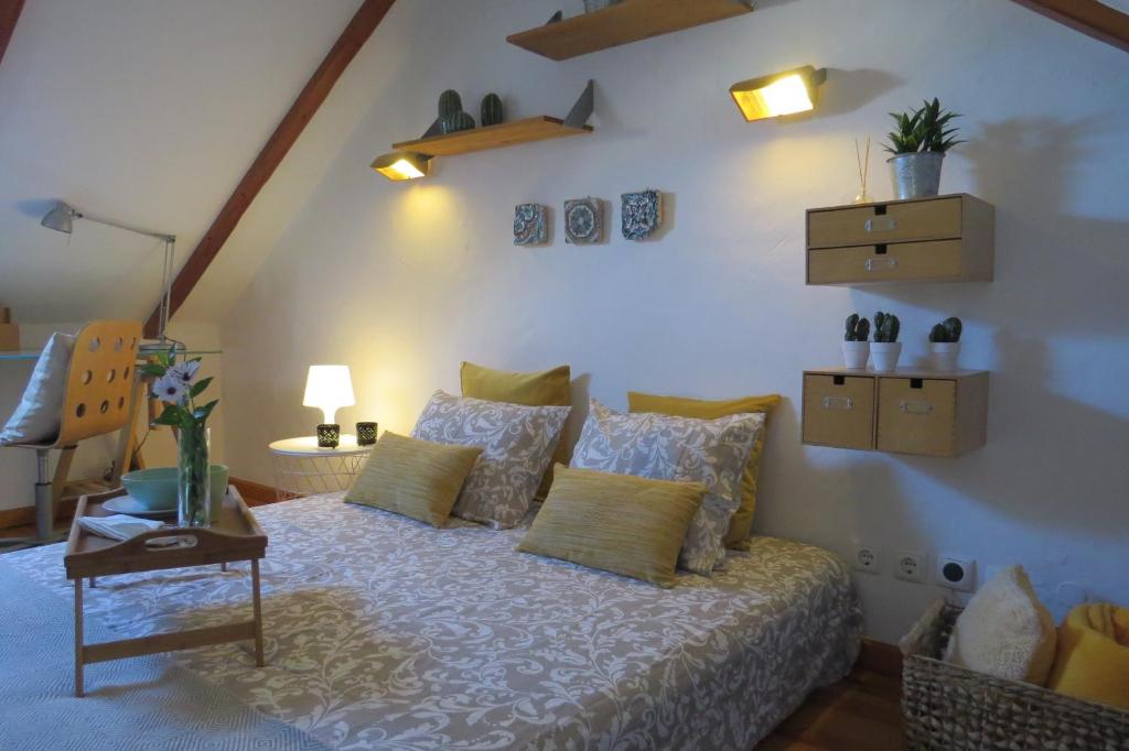 una camera da letto con un letto con cuscini e un tavolo di Casa do Largo ad Alcácer do Sal