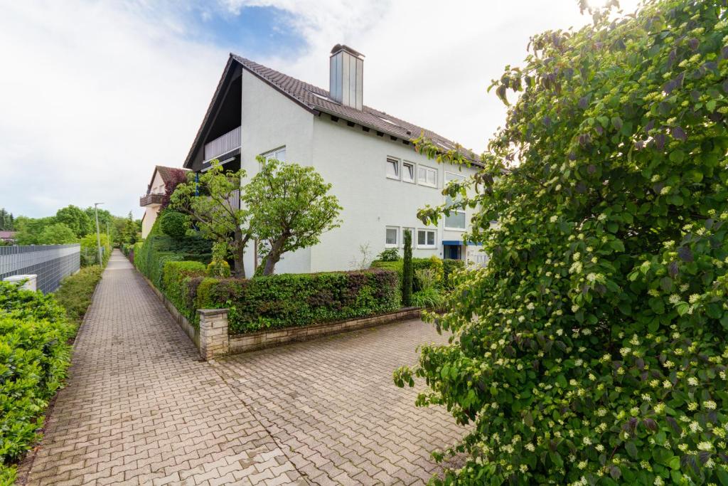 a brick path in front of a white house at Apartment with a view - Daheim am Wasserturm in Wörth am Rhein