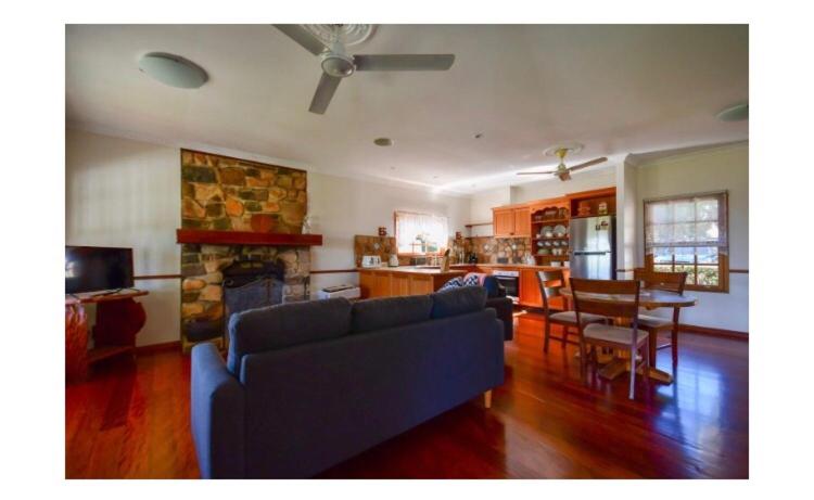 a living room with a blue couch and a fireplace at Lakefront holiday villa in Yungaburra