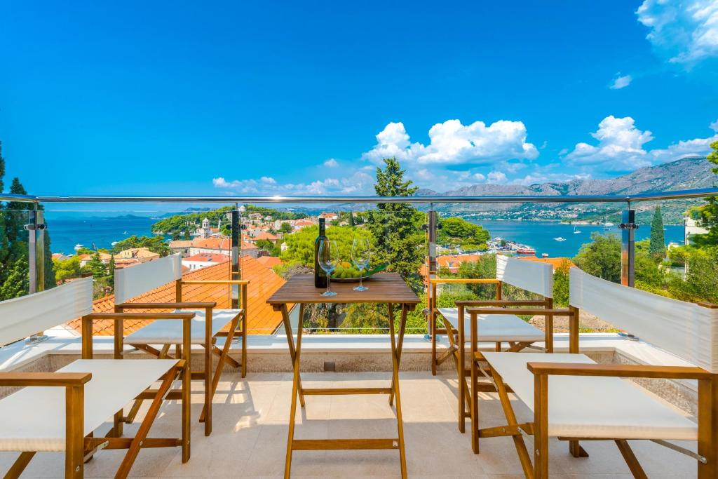 a balcony with a table and chairs overlooking the water at Villa Nespola Penthouse in Cavtat