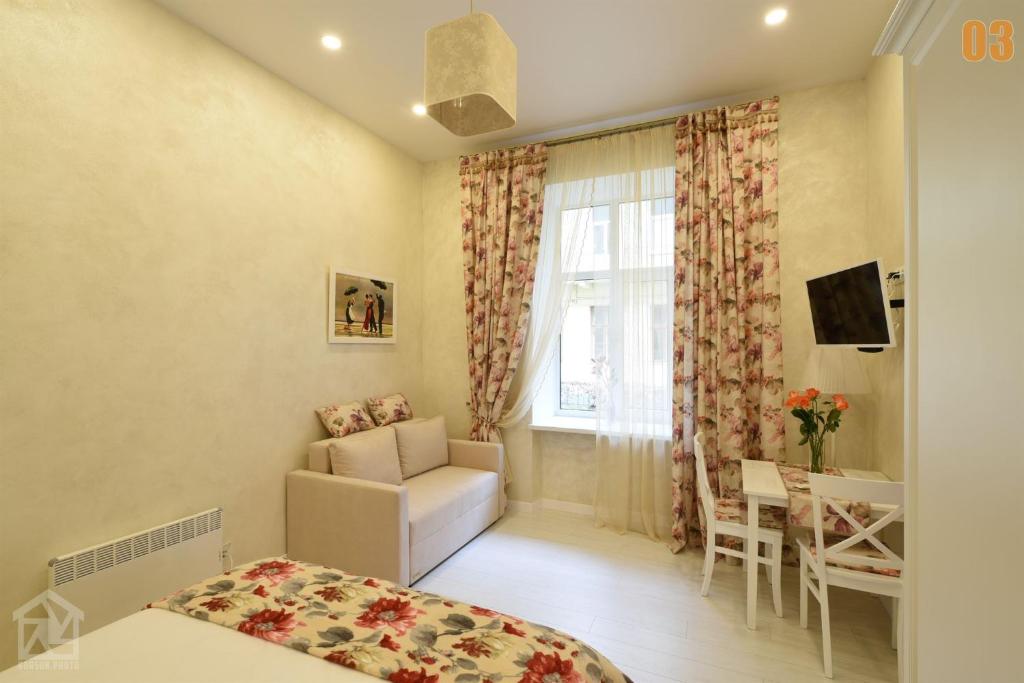 リヴィウにあるApartments Lucky home centre Lvivのベッド1台、椅子、窓が備わる客室です。