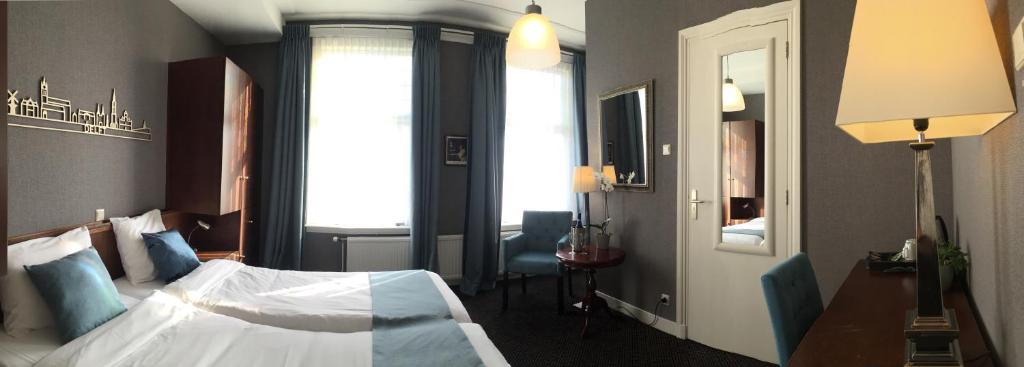 a hotel room with a bed and a mirror at Hotel Johannes Vermeer Delft in Delft