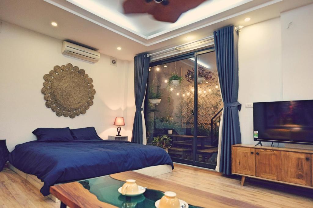 a bedroom with a bed and a flat screen tv at The Gallery House in Hanoi