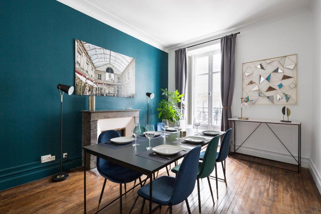 a dining room with a black table and blue walls at Le Prestige by Cocoonr in Nantes