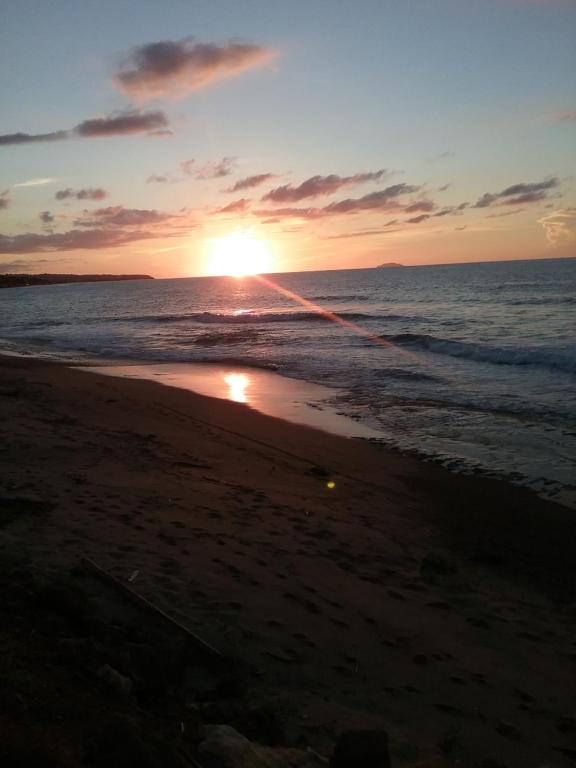 a sunset on a beach with the ocean at Ocean Dreams in Aguada