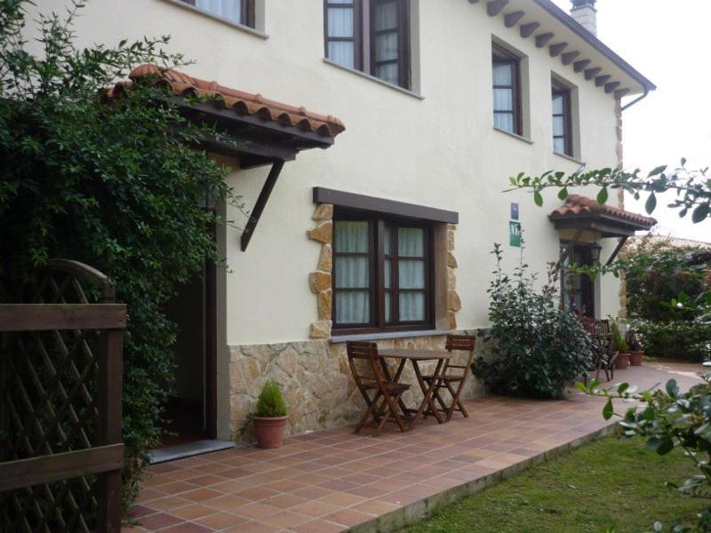 ein Haus mit einer Terrasse und einem Tisch davor in der Unterkunft Apartamentos Rurales La Caramba in Lamuño