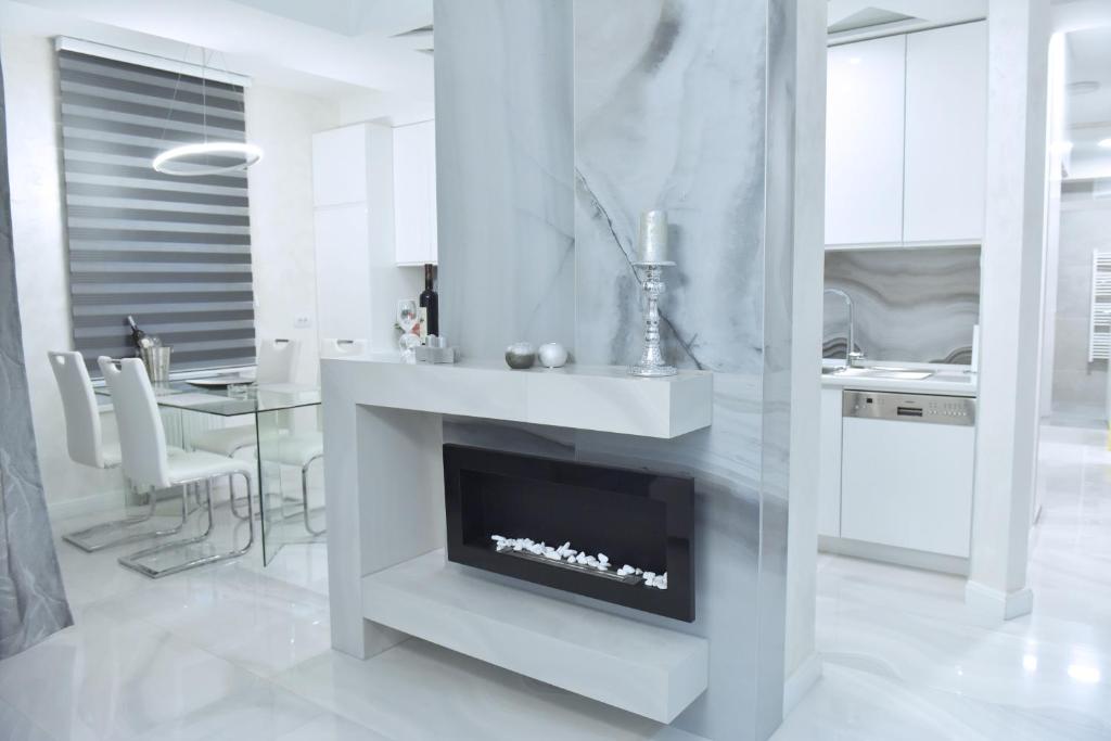 a white living room with a fireplace in it at N&L in Banja Luka