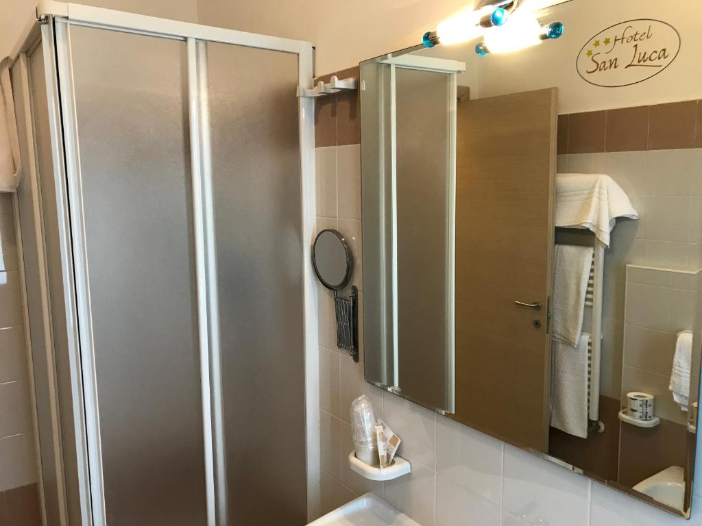 W łazience znajduje się prysznic i lustro. w obiekcie Hotel San Luca w mieście Rossano