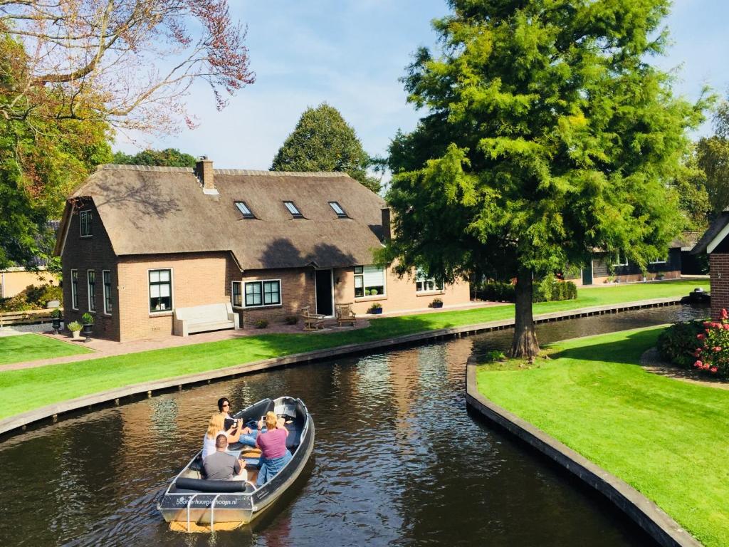 a group of people in a boat on a canal at Gieters Mooist in Giethoorn