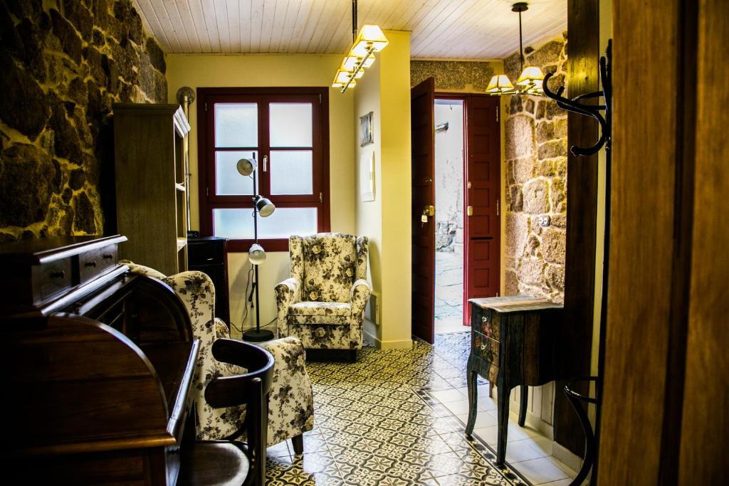 a hallway with two chairs and a table and a window at A casa da Igrexa in Ribadavia