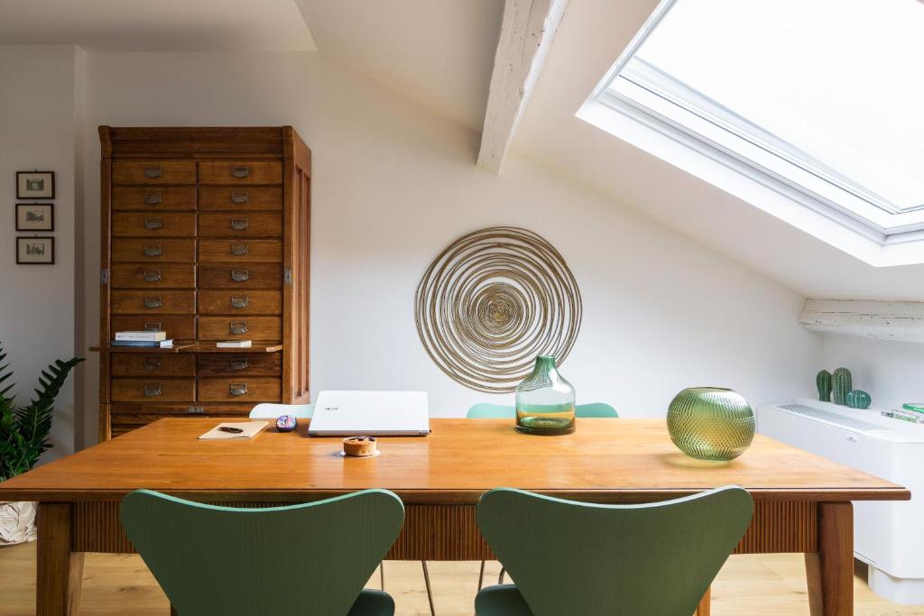 a room with a wooden table with chairs and a laptop at SPAZIO M&M Via Augusto Anfossi 10 in Milan