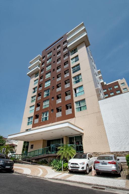 two cars parked in front of a building at Space Residence in Manaus