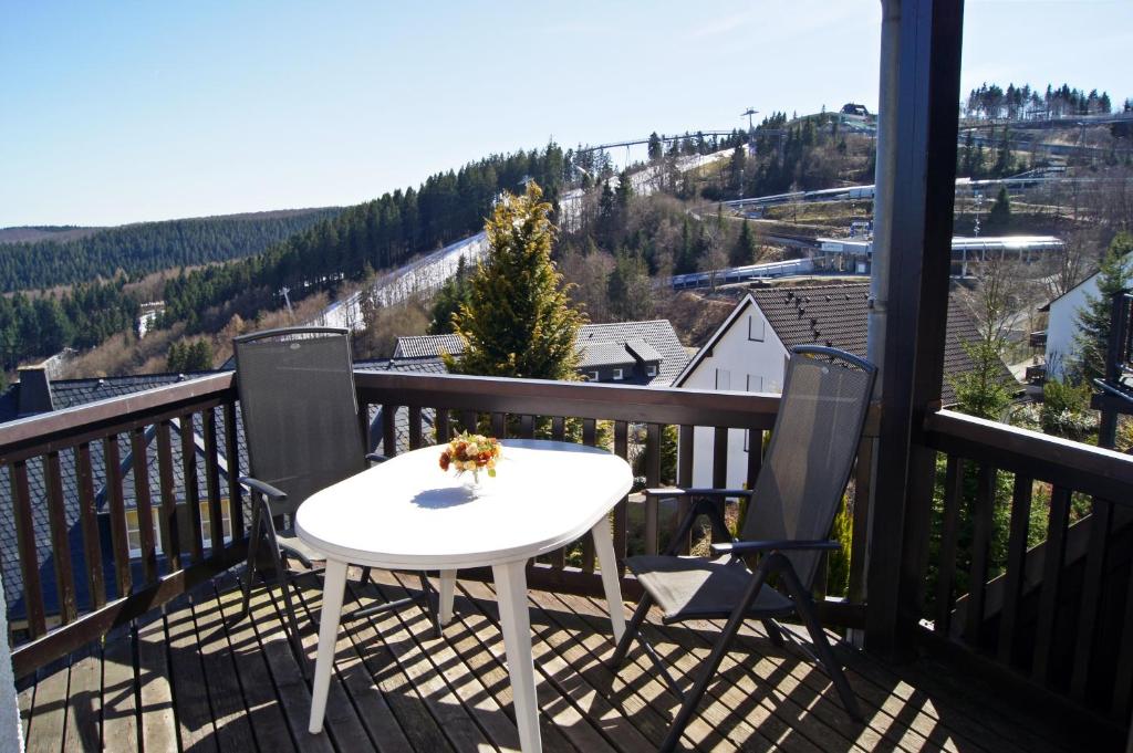 ヴィンターベルクにあるAppartement Kiefernweg Winterbergの白いテーブルとバルコニー(椅子2脚付)