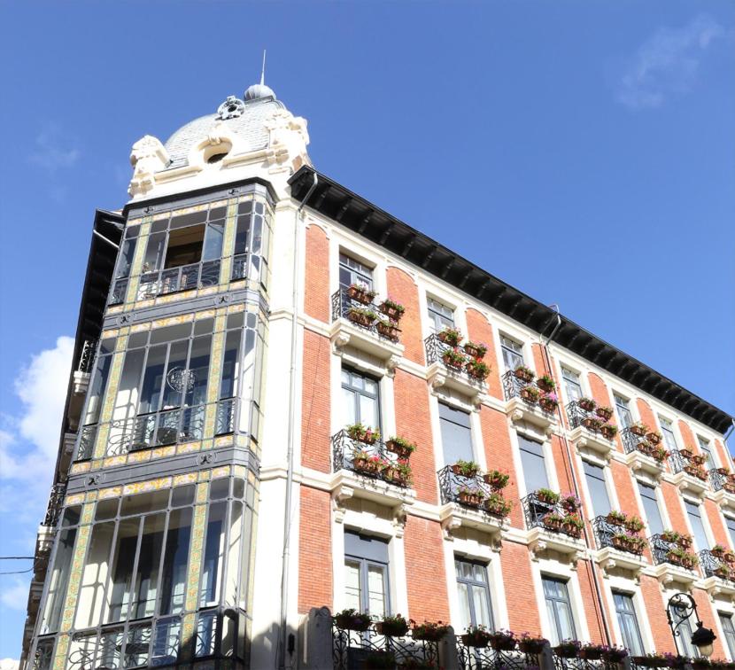 a tall building with a clock on the front of it at Leon Hostel in León