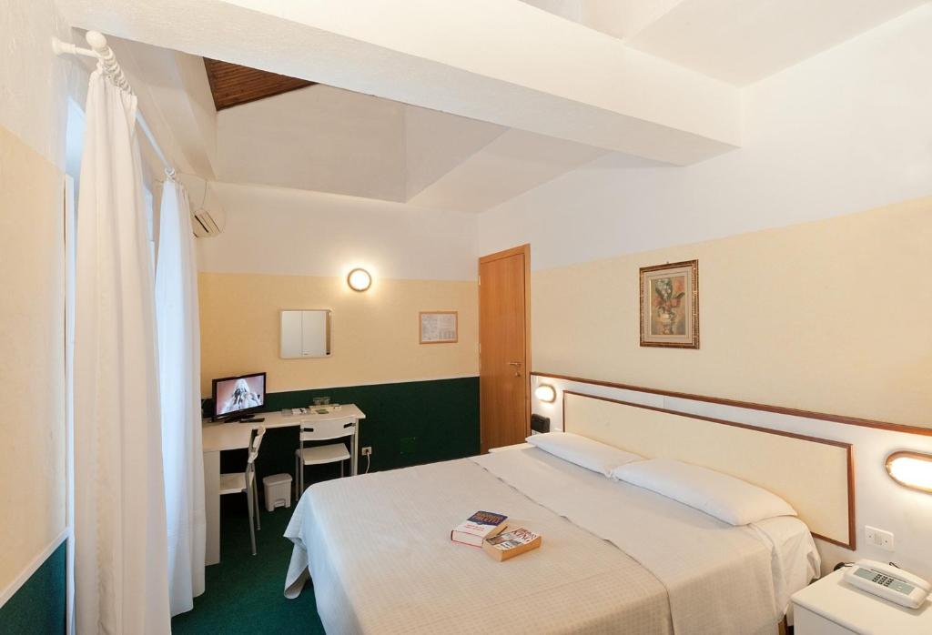 een hotelkamer met een bed en een bureau bij Hotel Eden in Baveno