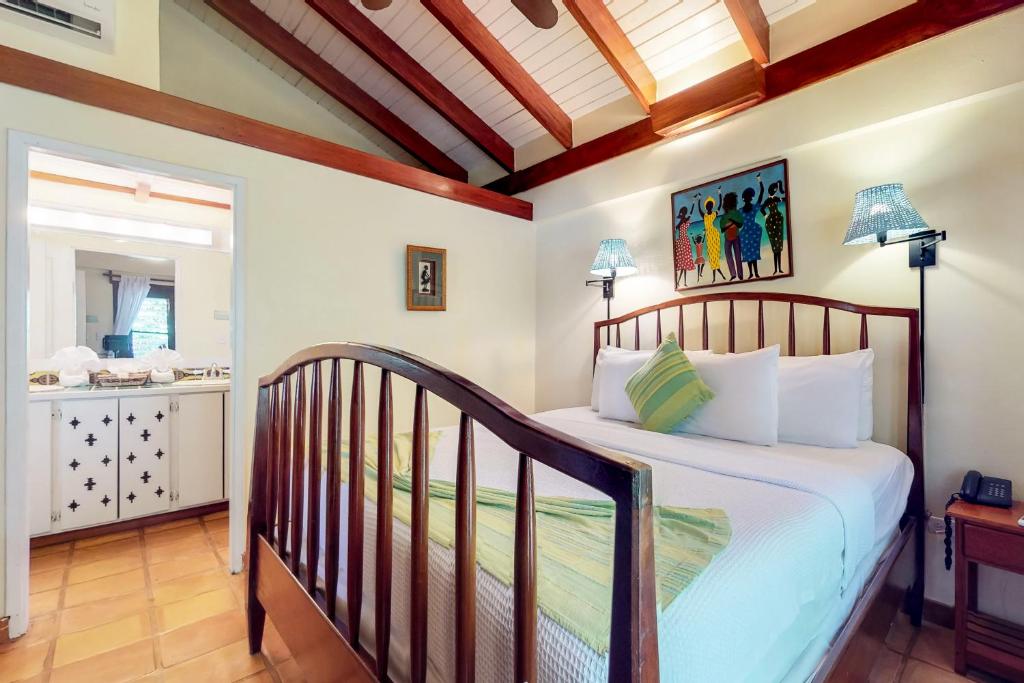 a bedroom with a bed and a bathroom at Condo #26 @ Beachside Villas in Placencia