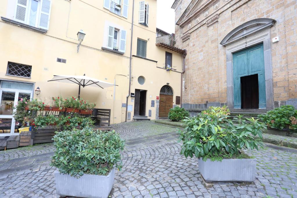 a courtyard with two potted plants and an umbrella at Casa Vacanze S.Angelo La Stella in Orvieto