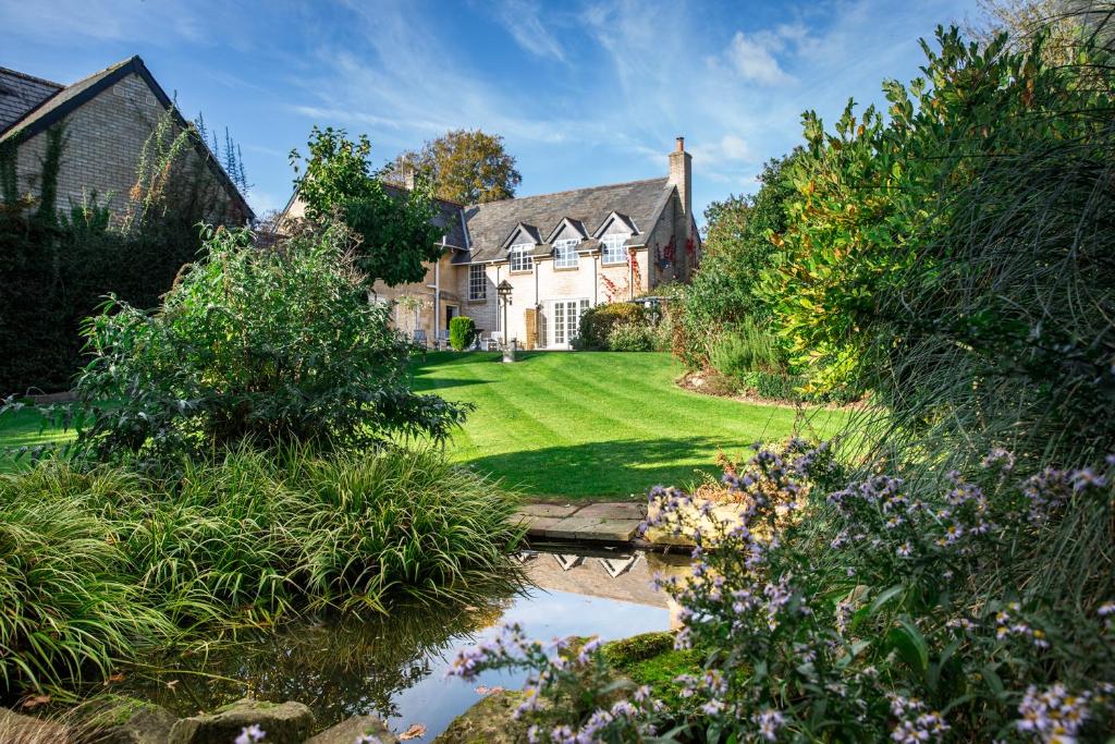 a house with a pond in front of a yard at Cricket Field House in Salisbury