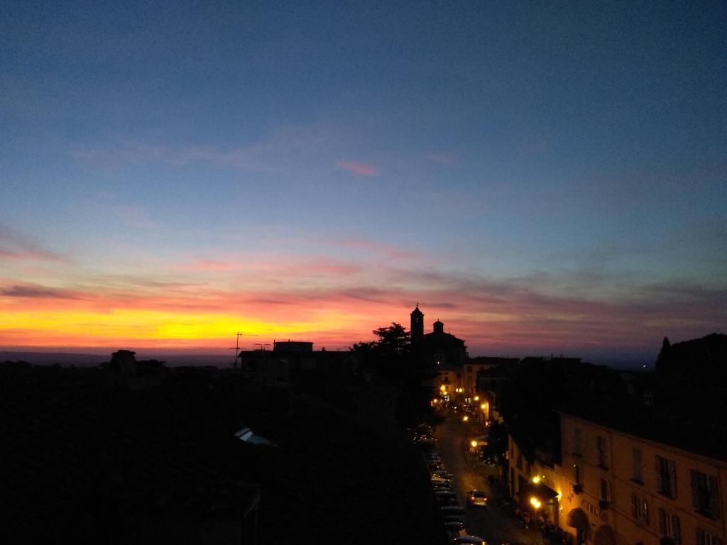 a sunset over a city with a clock tower at La casa dei Fiori in Vetralla