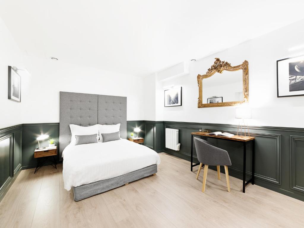 a bedroom with a bed and a desk and a mirror at LivinParis - Luxury 3 Bedrooms République I in Paris