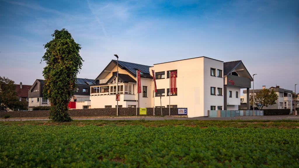 a group of houses with a tree in the foreground at Hotel am Stadtrand in Ostfildern