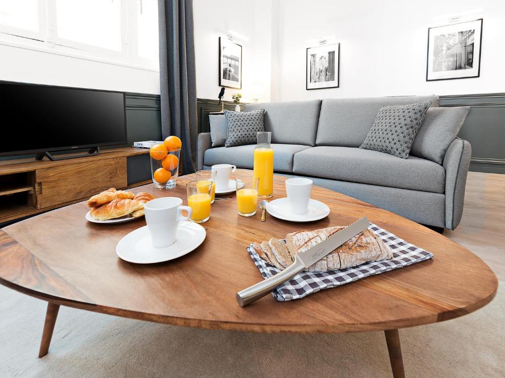 a coffee table with food on it in a living room at LivinParis - Luxury 3 Bedrooms République I in Paris