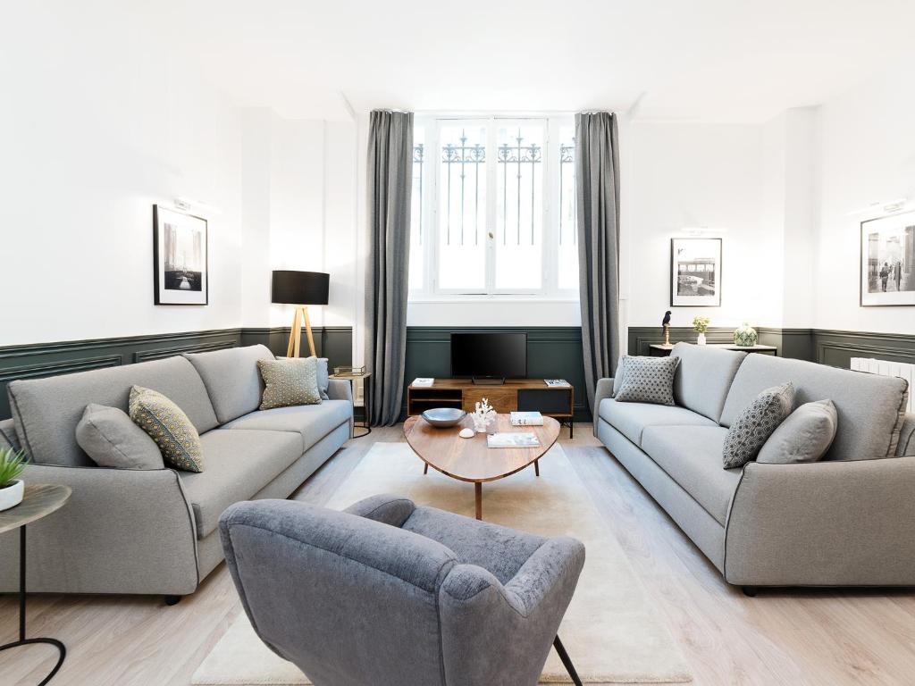 un soggiorno con 2 divani e un tavolo di LivinParis - Luxury 3 Bedrooms République I a Parigi