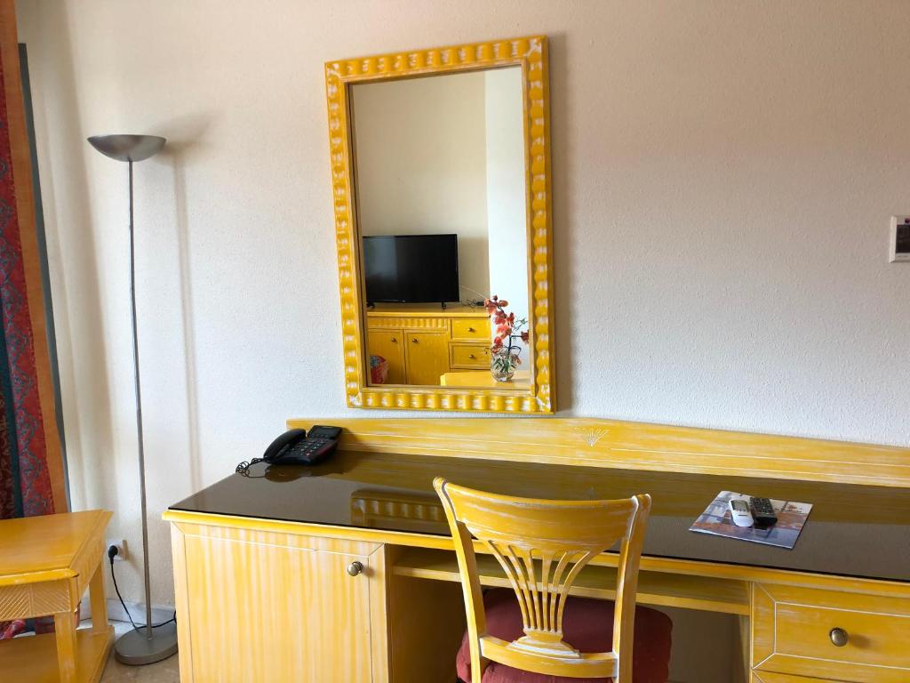 a mirror and a desk with a chair in a room at Hotel La Galleria in Le Lamentin