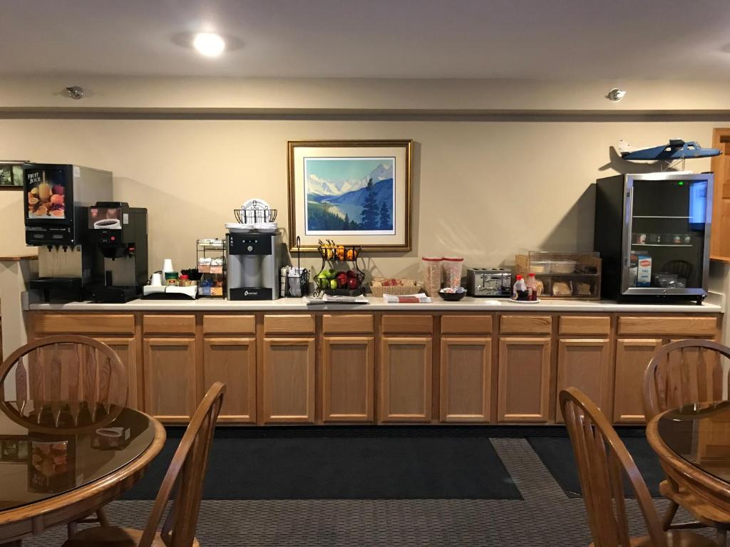 a kitchen with a table and chairs and a refrigerator at Lakeshore Inn & Suites in Anchorage