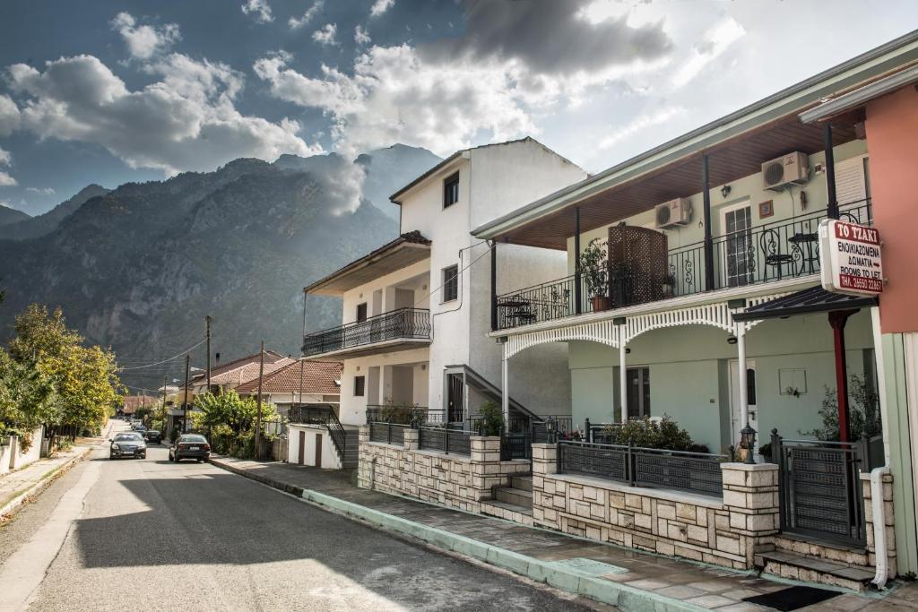 a building on a street with a mountain in the background at Guesthouse To tzaki in Konitsa