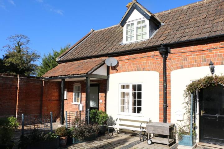 a brick house with a bench in front of it at Prince Hill Cottages in Worton