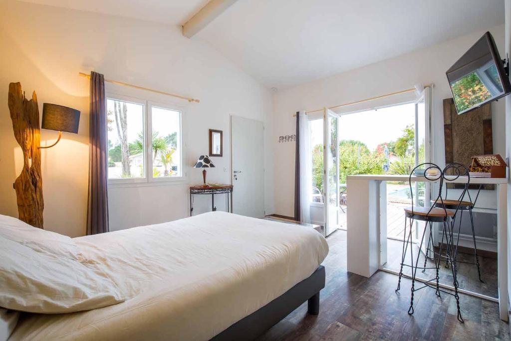 a bedroom with a large bed and a balcony at Villa Mogador Piscine et Balnéo in Andernos-les-Bains