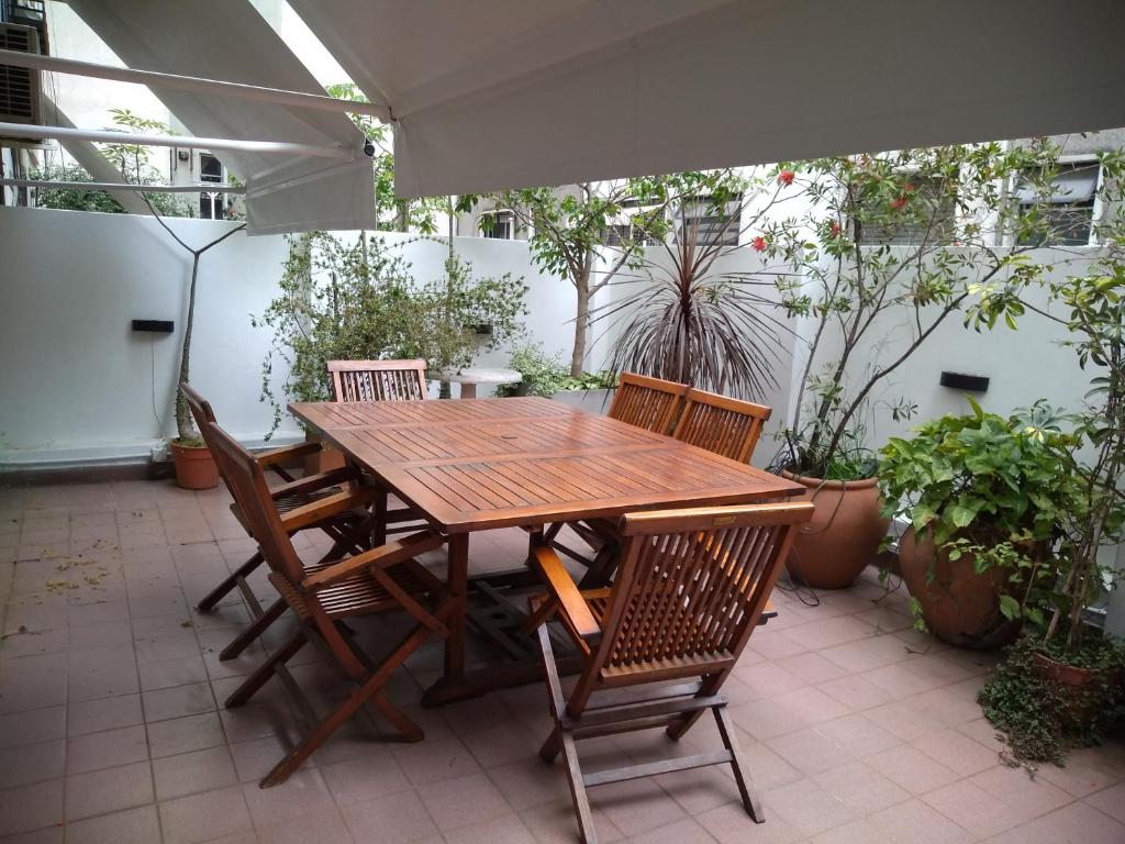 drewniany stół i krzesła na patio w obiekcie Palermo 3 Habitaciones privadas w BuenosAires