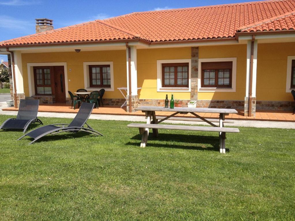 a picnic table and chairs in front of a house at Apartamentos Casa Carin in Cadavedo