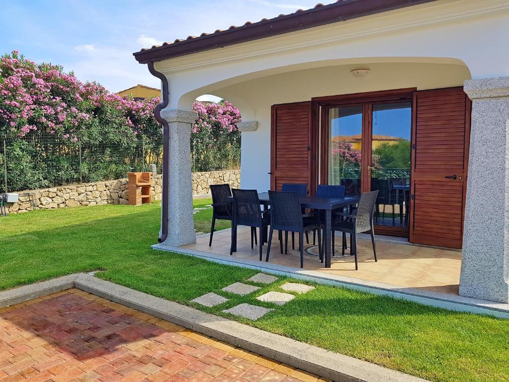 a patio with a table and chairs in a yard at villette acquamarina Budoni in Budoni